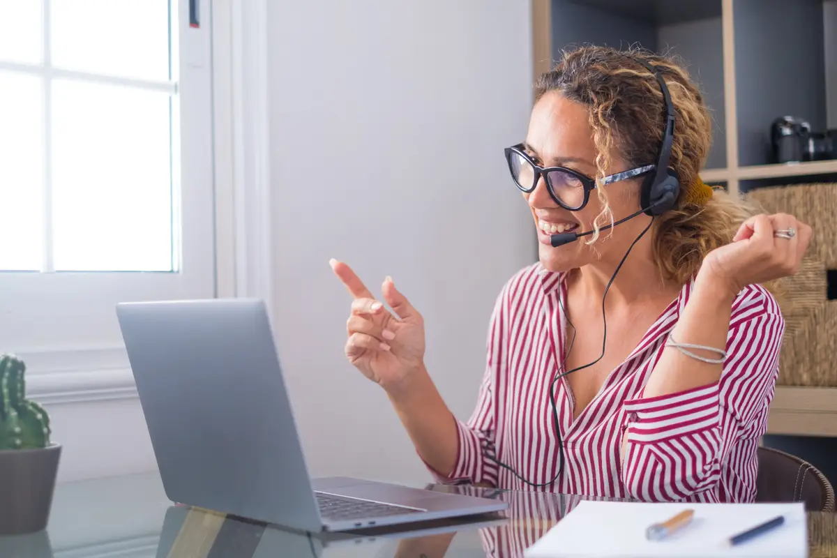 Attractive caucasian woman working as a virtual tour guide for Greenland Private Tours, engaging with clients from her home office