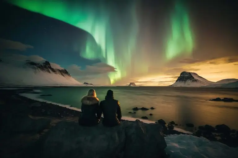 Tourists enjoying a spectacular Northern Lights display over a snowy Greenlandic landscape during a private tour