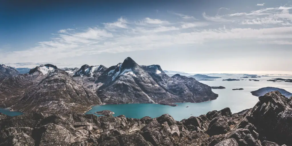 Aerial view of the majestic Ukkusissat mountain and surrounding Nuup Kangerlua fjord in Greenland, showcasing the stunning rocky landscape and turquoise waters ideal for adventure travel.